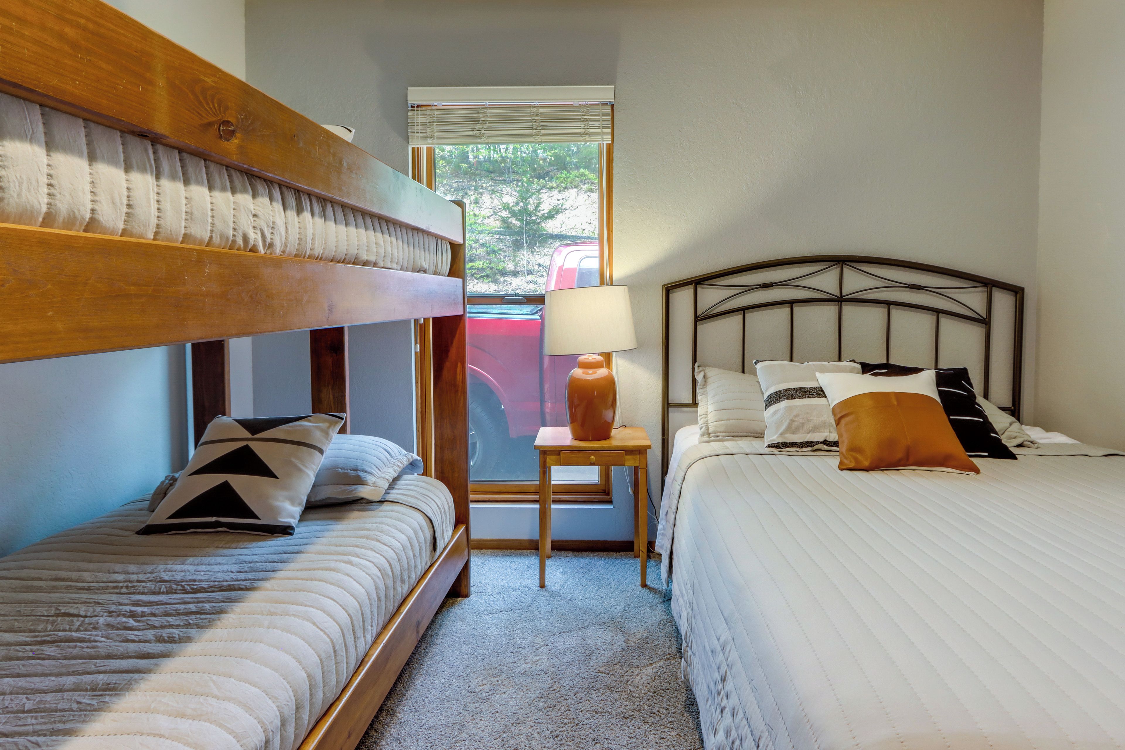 Una habitación con dos camas, una ventana y una lámpara.