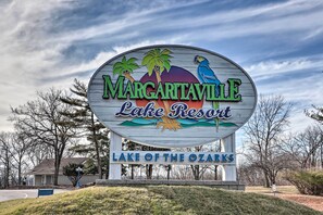 Schild für Margaritaville Lake Resort mit Palmen und einem Papagei.