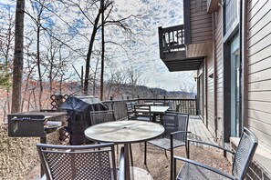 Eine Terrasse im Freien mit Metallstühlen und -tischen, einem Grill und einem überdachten Bereich.