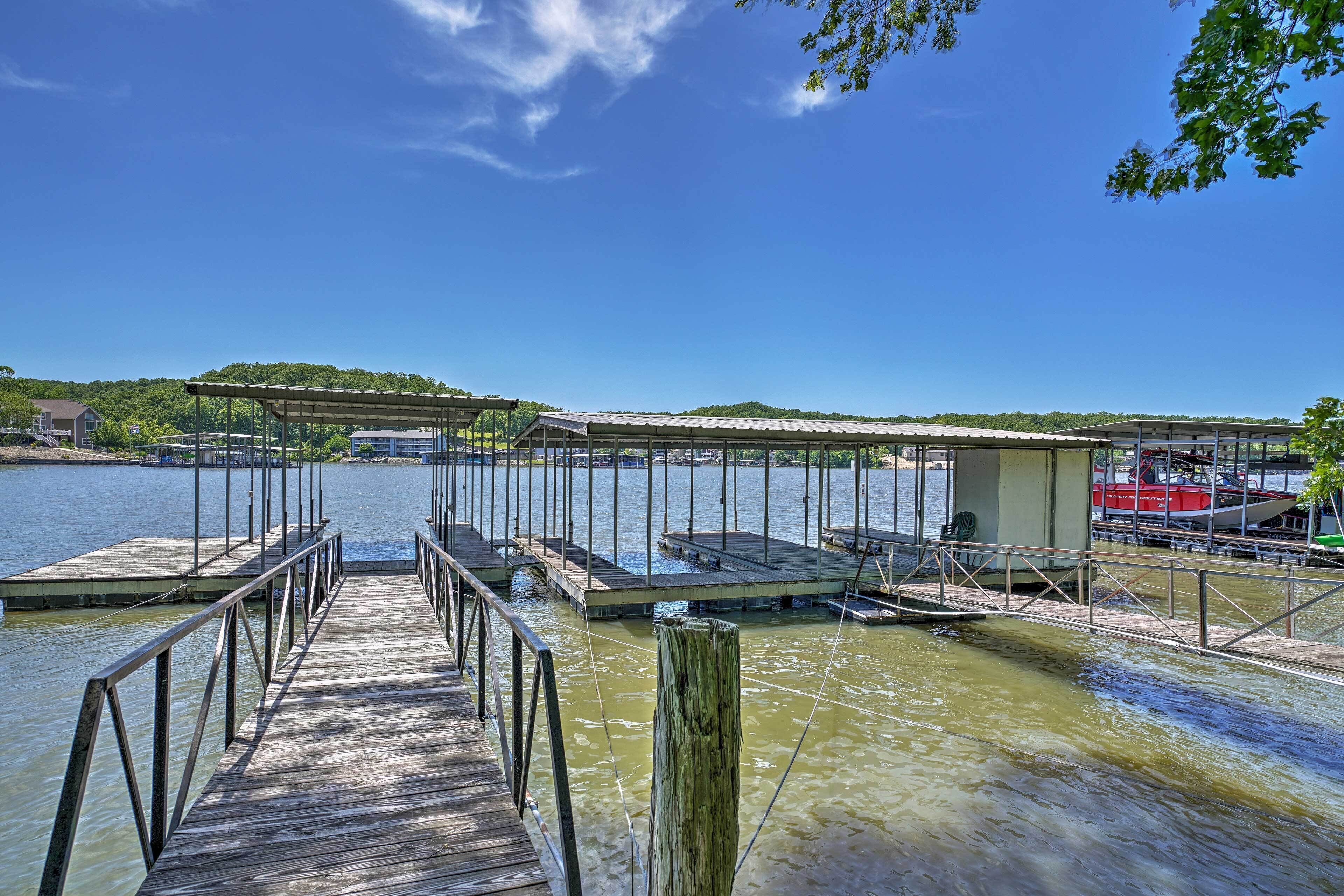 A wooden dock leading to a covered area with a boat docked nearby.