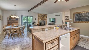 Una cocina amplia con una isla grande, muebles de madera y una pared de acento de piedra.
