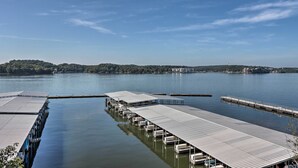 Een jachthaven met aangemeerde boten, kalm water en een verre kustlijn met bomen en gebouwen.
