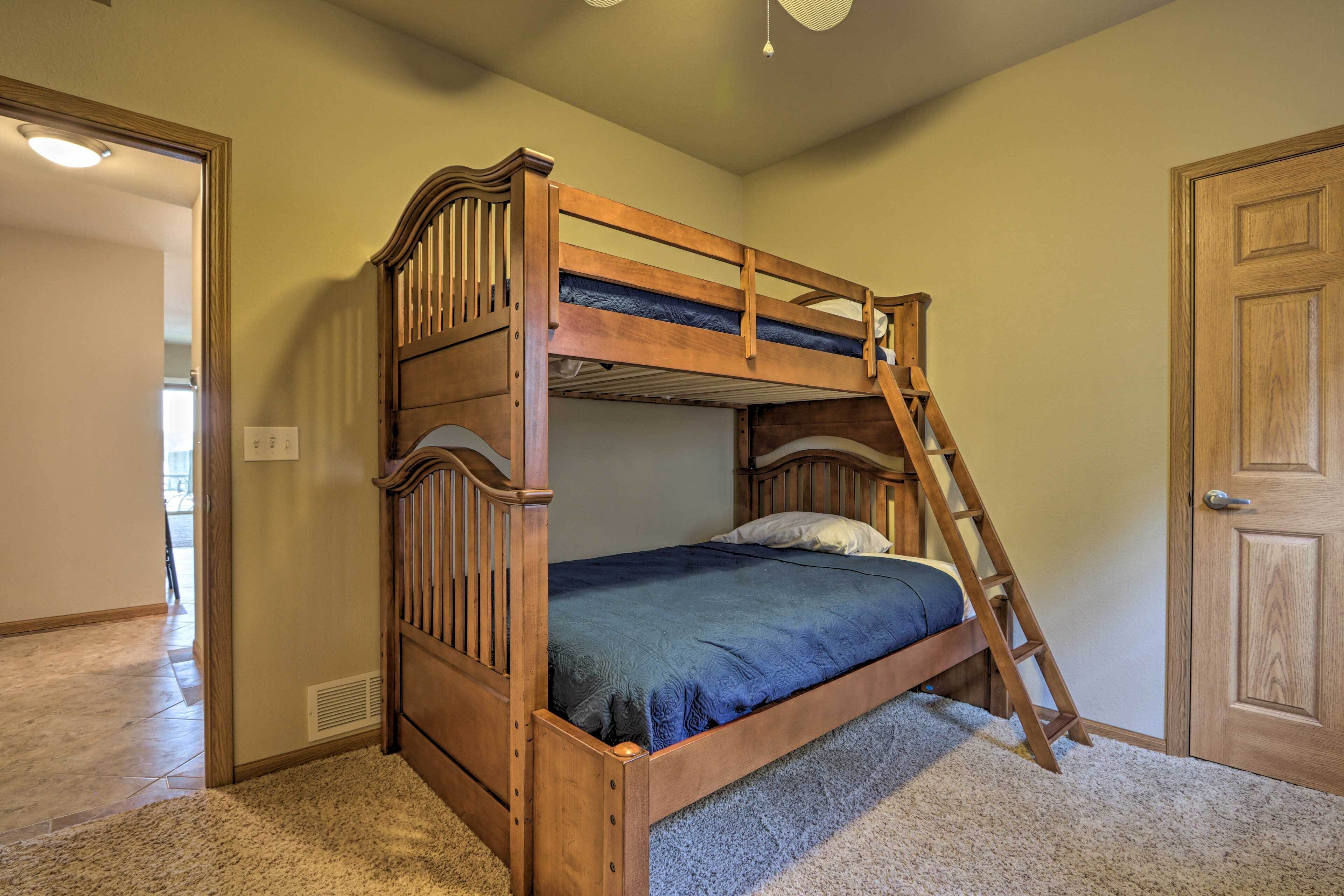 A bunk bed with a ladder, a door, and a carpeted floor.