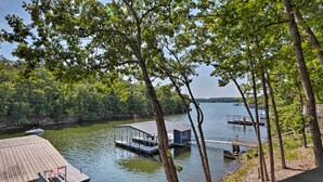 A lakeside cabin with a dock and a small boat.
