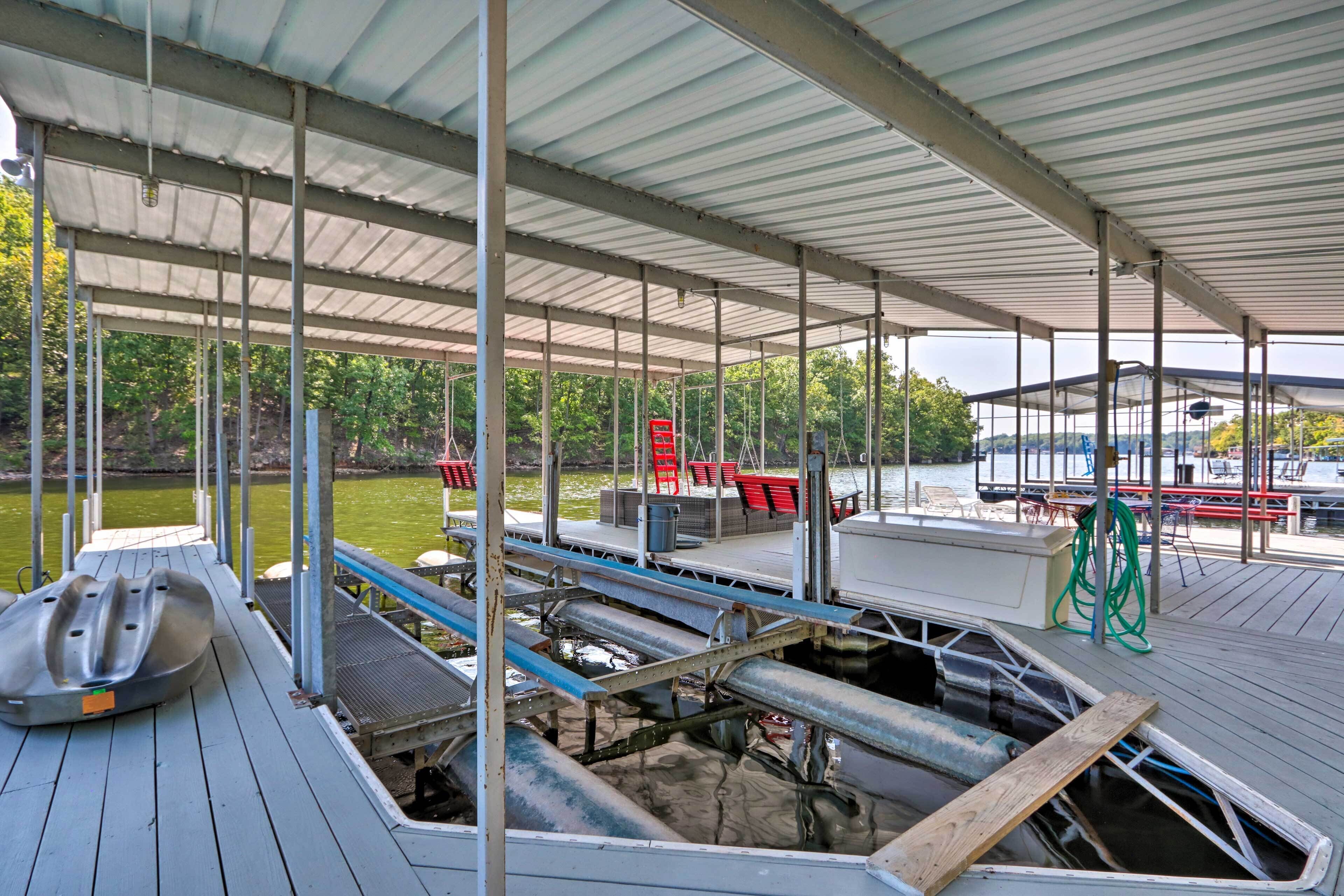 A covered dock area with a boat, seating, and a view of the water.