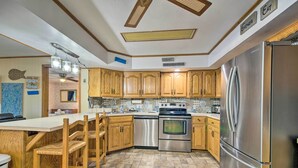 A kitchen with wooden cabinets, a stainless steel refrigerator, and a built-in oven. - Boat Dock + Slides: Lakefront Gravois Mills Home (Gravois Mills)