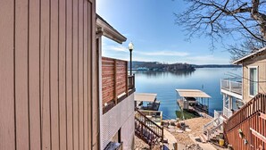 Una propiedad frente al lago con muelle de madera, mobiliario exterior y vistas al lago.