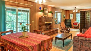 Un salón acogedor con chimenea, muebles de madera y ventanas amplias.