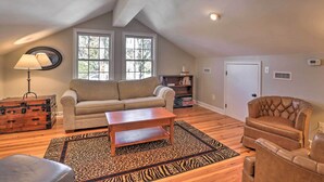 A cozy living room with a sofa, armchair, wooden coffee table, and a zebra-patterned rug. - Lakefront Retreat w/ Game Room & Private Dock! (Bonneau)