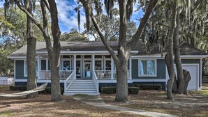 A two-story house with a porch, surrounded by trees and a hammock. - Lakefront Retreat w/ Game Room & Private Dock! (Bonneau)