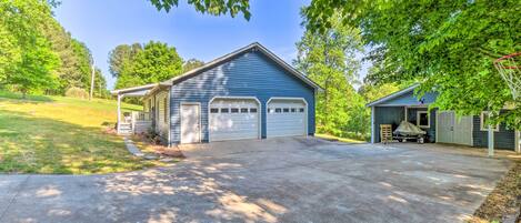 Une maison à deux étages avec un garage et une véranda couverte.