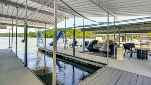 A covered dock area with a water slide, lounge chairs, and a grill. - Dock & Water Slide: Family Lake of the Ozarks Home (Gravois Mills)