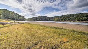 A river with a grassy bank and a forested hill in the background. - Waterfront Home w/ Fire Pit on Table Rock Lake (Golden)
