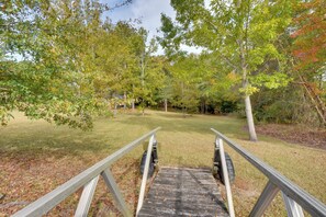 A wooden deck leading to a grassy area surrounded by trees. - Lakefront Westminster Retreat w/ Boat Dock! (Westminster)