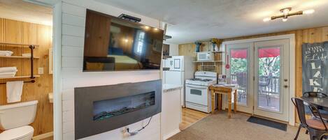 A compact kitchen with a built-in TV, a microwave, and a stove.