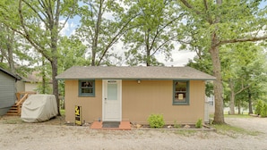 A small, single-story building with a covered porch, a door, and a small window. - Lakeside Reeds Spring Home w/ Deck & Pool Access! (Kimberling City)