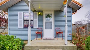 A house with a porch, two red chairs, a white door, and a 'Home Sweet Home' mat. - Walk to Dtwn: New Orleans-themed Lebanon Cottage (Lebanon)