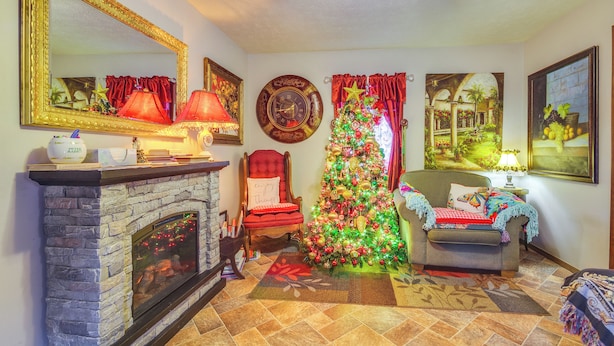 A cozy living room with a fireplace, a Christmas tree, and a large mirror on the wall. - Walk to Dtwn: New Orleans-themed Lebanon Cottage (Lebanon)