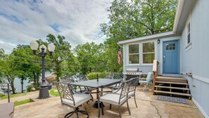 A patio with a table and chairs, a grill, and a blue door. - 8 Mi to Beach: Lake-view Haven in Linn Creek! (Linn Creek)