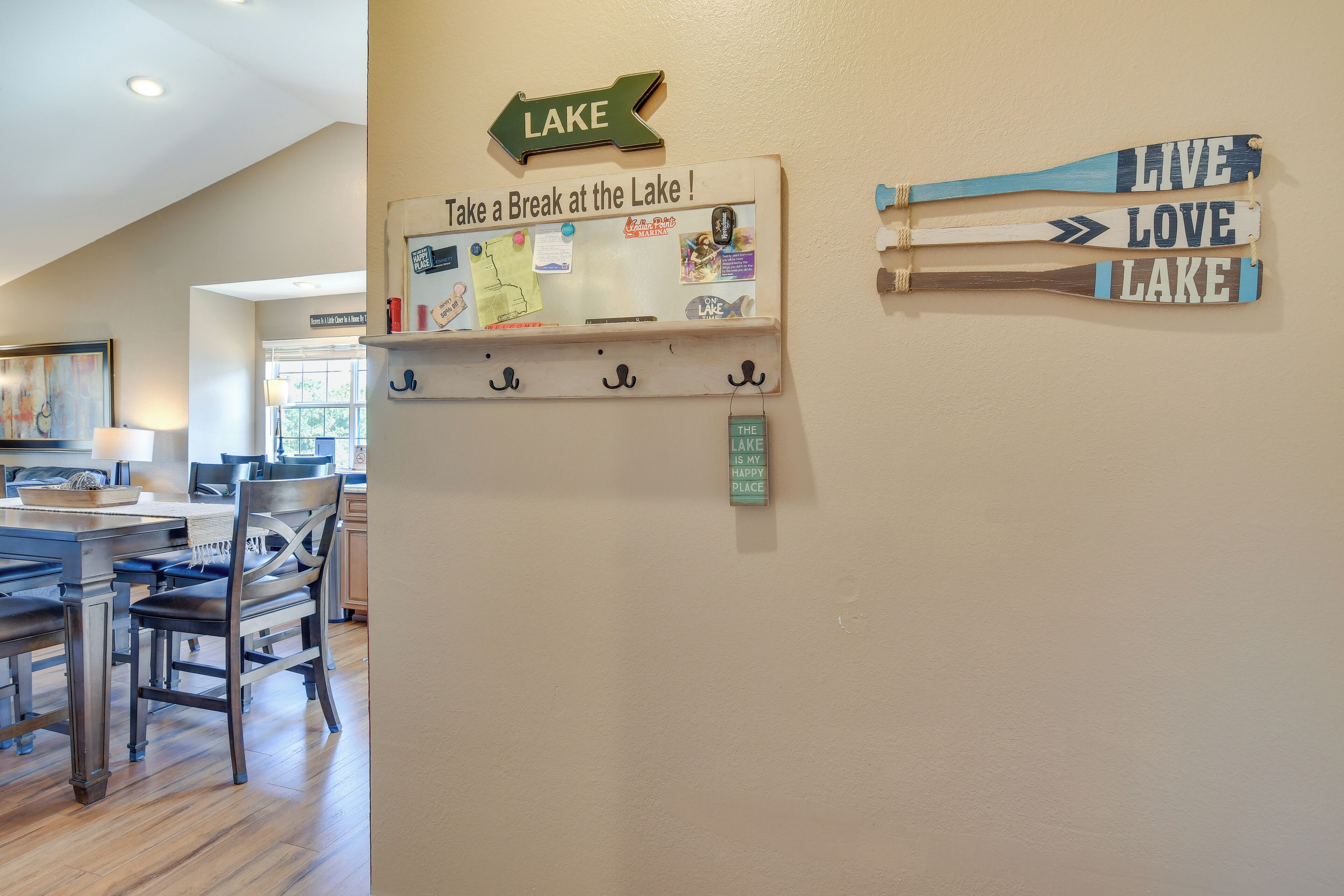 A wall with a sign that says "Take a Break at the Lake!" and a wooden sign with "LIVE LOVE LAKE".