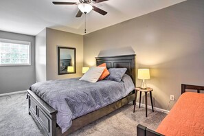A bedroom with a bed, a ceiling fan, a nightstand with a lamp, and a chair. - Modern Home w/ Yard + Deck, 1 Mi to Clemson U! (Clemson)