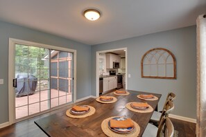 A dining area with a large table, chairs, and a view through a glass door to an outdoor patio. - Modern Home w/ Yard + Deck, 1 Mi to Clemson U! (Clemson)