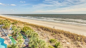 A beach resort with a swimming pool, lounge chairs, and a view of the ocean. - Oceanfront Oasis in North Myrtle Beach (North Myrtle Beach)