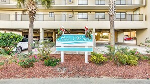 A sign for Sea Winds with a parking garage in the background. - Oceanfront Oasis in North Myrtle Beach (North Myrtle Beach)