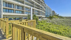 A multi-story hotel with balconies, a wooden deck, and a view of the beach. - Oceanfront Oasis in North Myrtle Beach (North Myrtle Beach)