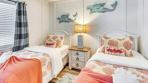 A bedroom with two beds, a nightstand, a lamp, and decorative wall art. - Oceanfront Oasis in North Myrtle Beach (North Myrtle Beach)
