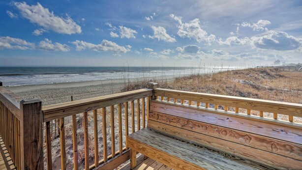 A wooden deck with a bench overlooking a beach. - Magnolia Pointe Condo With Community Pool & More! (Myrtle Beach)