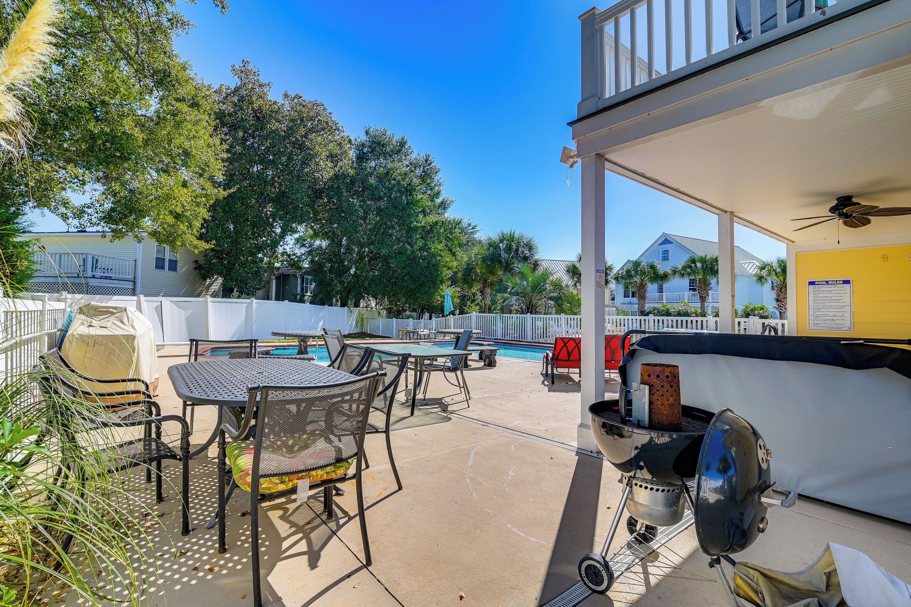 An outdoor patio with a grill, pool table, and seating area.