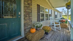 A porch with hay bales, pumpkins, and potted plants. - Monett Family Ranch Home w/ Fireplace & Huge Deck! (Purdy)