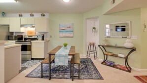 A compact kitchen with a dining area, a small bar, and a view of the ocean through a window. - Myrtle Beach Condo 2 Mi to Surfside Beach! (Surfside Beach)