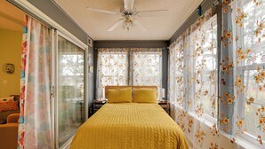 A bedroom with a bed, a ceiling fan, and floral curtains. - Myrtle Beach Condo 2 Mi to Surfside Beach! (Surfside Beach)