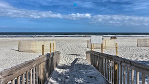 A wooden boardwalk leading to a sandy beach with a clear sky. - Walk to Beach: Nautical Hilton Head Resort Condo! (Hilton Head Island)