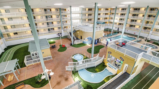 A multi-level indoor complex with a central swimming pool, multiple balconies, and various seating areas. - Walk to Beach: Nautical Hilton Head Resort Condo! (Hilton Head Island)