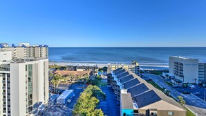 A high-rise hotel with multiple floors, a parking lot, and a view of the beach. - Walk to Ocean: Myrtle Beach Condo w/ Views! (Myrtle Beach)