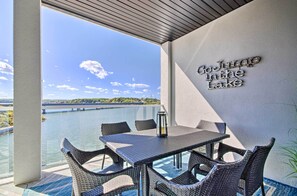 Un balcon agrémenté de meubles en osier, d’une table et d’un panneau indiquant : « Baignade autorisée ».