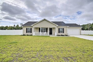 A two-story house with a front porch, a garage, and a well-maintained lawn. - 3 Mi to Golf: Loris Home w/ Big Private Yard! (Loris)