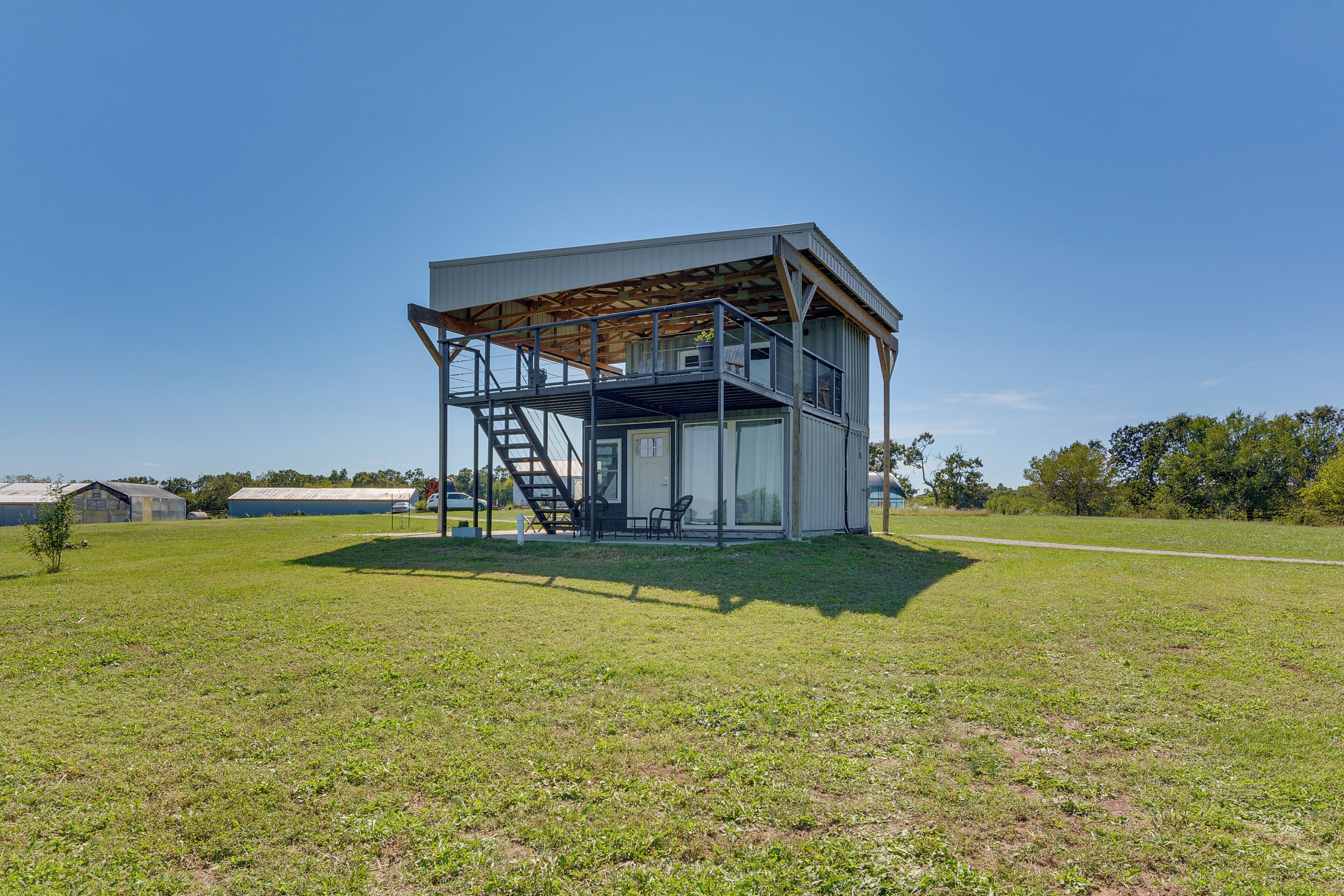 Un bâtiment moderne doté d’une structure métallique, d’un escalier et d’un espace extérieur abrité.