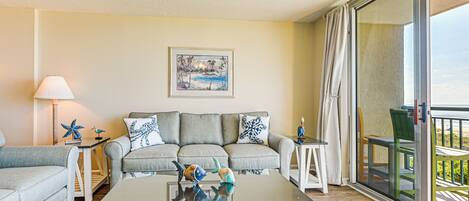 A living room with a sofa, a coffee table, and a painting on the wall.
