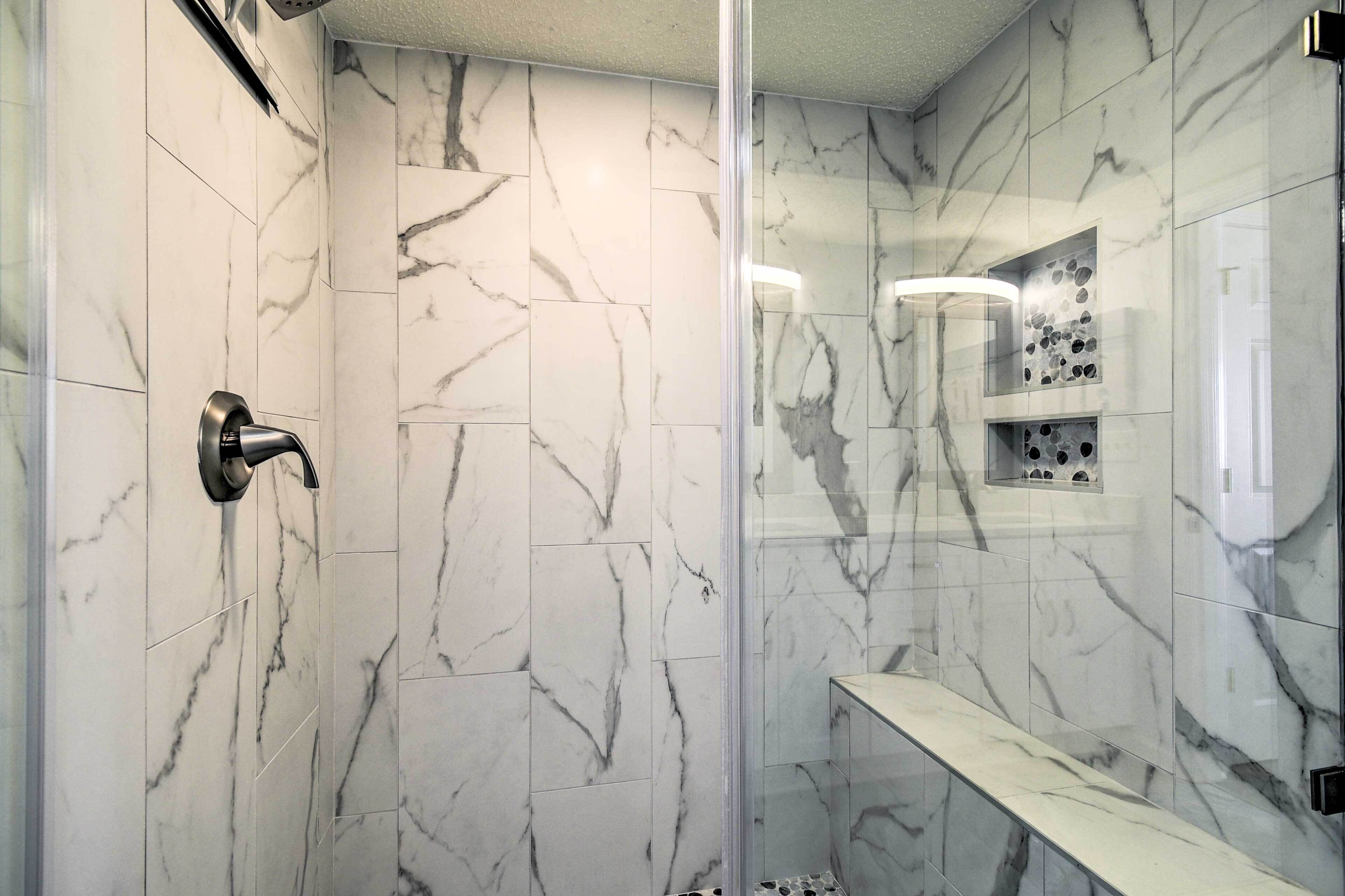 Ein modernes Badezimmer mit Marmorwänden und einer Glasdusche.