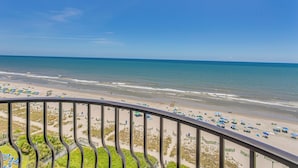 A beach view from a balcony with a railing, sandy beach, and ocean. - Oceanfront Condo w/ Balcony in Myrtle Beach! (Myrtle Beach)