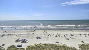 A beach with umbrellas, beach chairs, and people. - Ocean-view Penthouse Condo in North Myrtle Beach! (North Myrtle Beach)