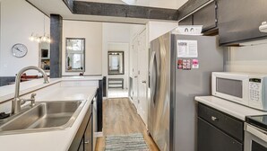 A modern kitchen with stainless steel appliances, a built-in microwave, and a sink. - Osage Beach Getaway - 1 Mi to Margaritaville Fun! (Osage Beach)