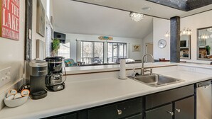 A modern kitchen with a large mirror, a coffee maker, and a sink. - Osage Beach Getaway - 1 Mi to Margaritaville Fun! (Osage Beach)