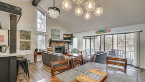 A spacious living room with a wooden dining table, comfortable seating, and a fireplace. - Osage Beach Getaway - 1 Mi to Margaritaville Fun! (Osage Beach)