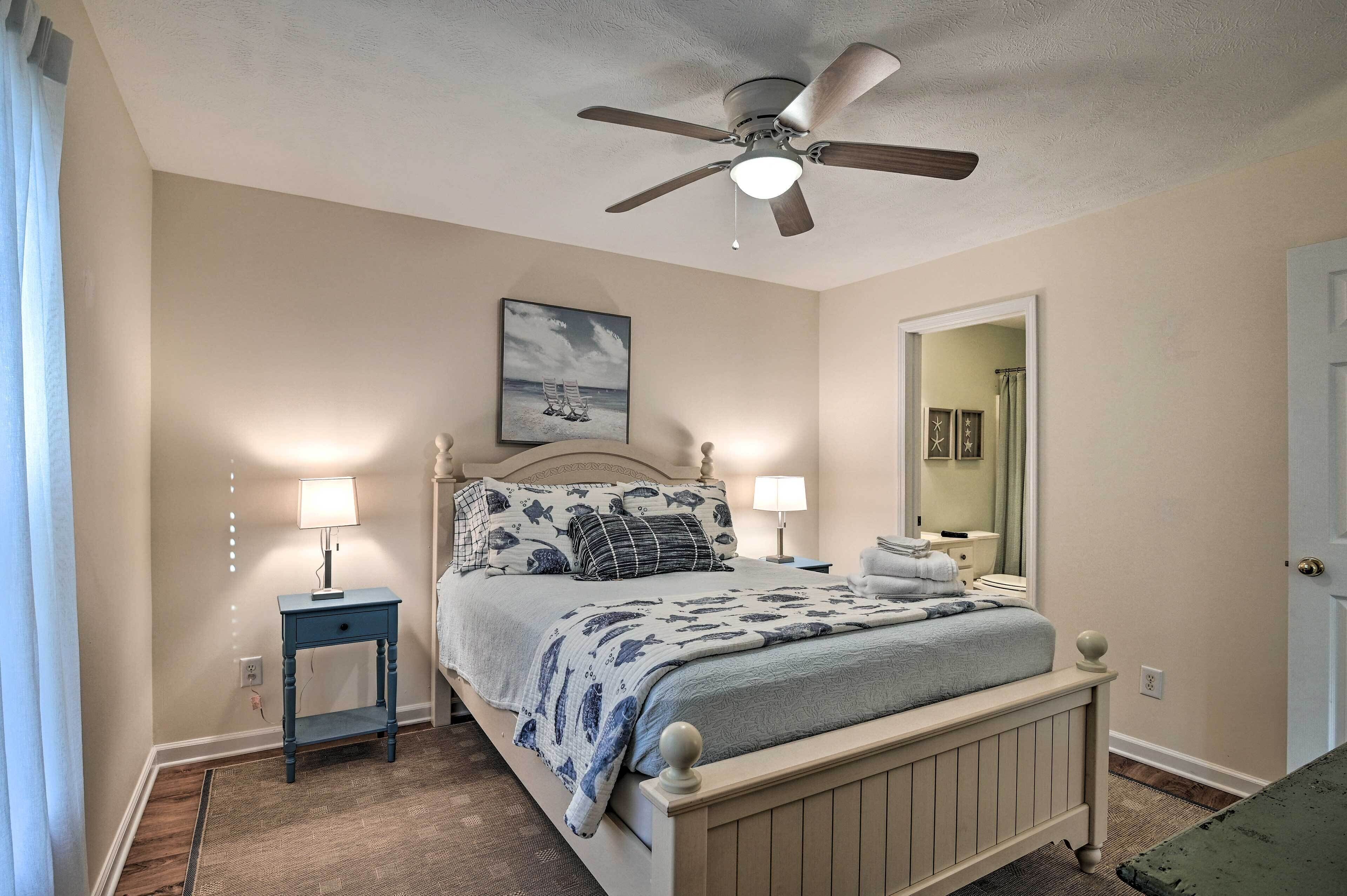 Une chambre à coucher avec un lit, des lampes de chevet, un ventilateur de plafond et une table de chevet.