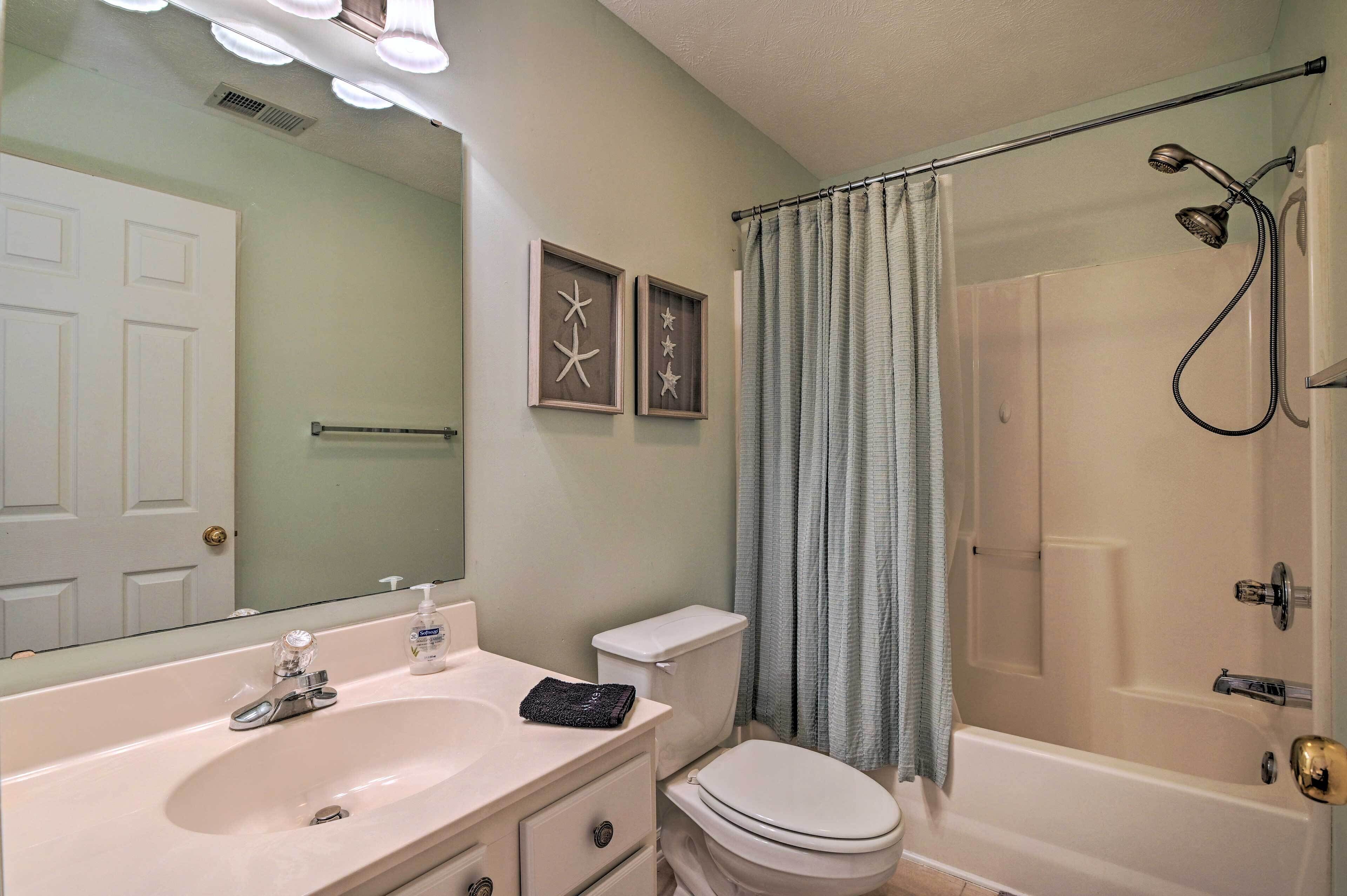 A bathroom with a sink, toilet, and bathtub. There are two framed star decorations on the wall.